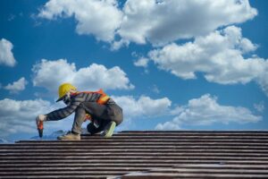 Homeowner examining curled shingles and rusted metal roofing from the ground after seasonal weather.